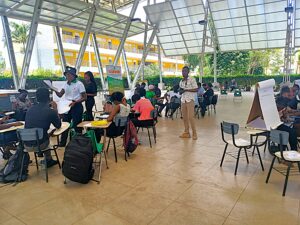 An image of a group of people attending a conference in an open-air pavilion in Haiti.